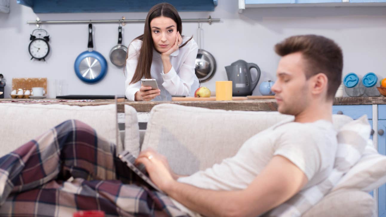 Wife Asks Her Husband To Quit His 'Dream Job' And Get A Better Paying One working wife resents work-from-home husband typing on computer on couch