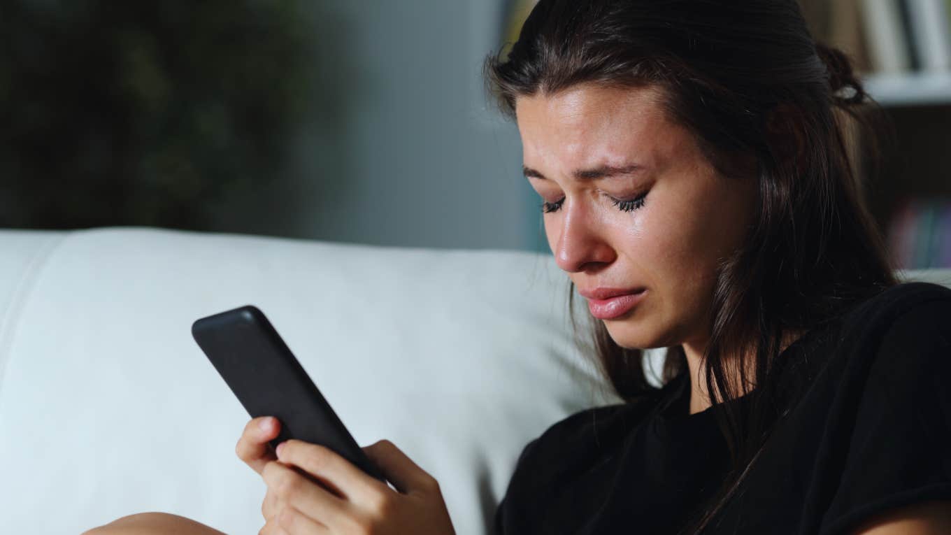 Woman Finds Herself Single After Being ‘Stonewalled’ By Her Boyfriend For Over A Week woman cries on couch while waiting for response on phone