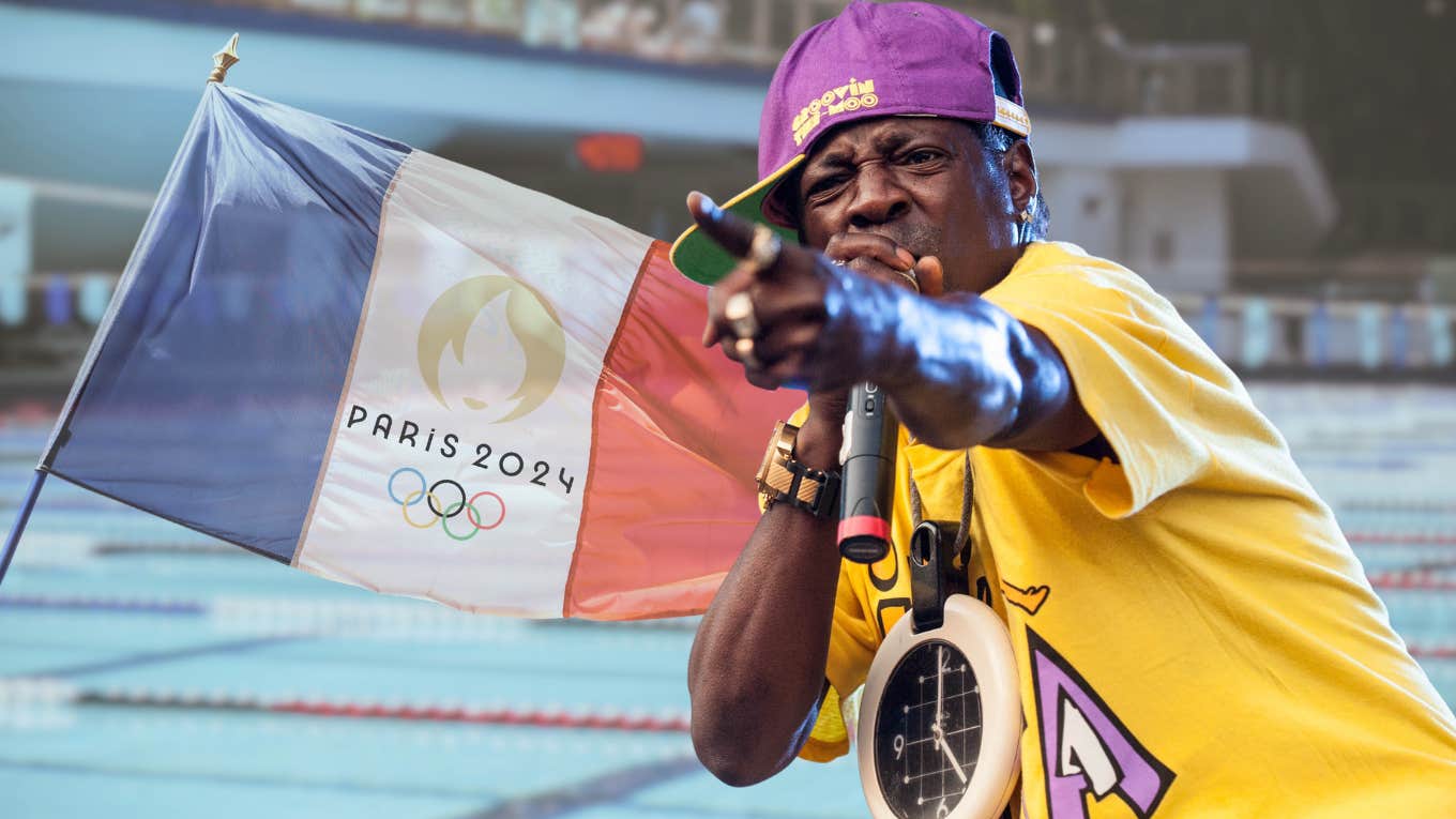 Inside Flavor Flav's Olympic Sponsorship Of USA Women’s Water Polo Flavor Flav standing in front of water polo team pool and Olympics flag.