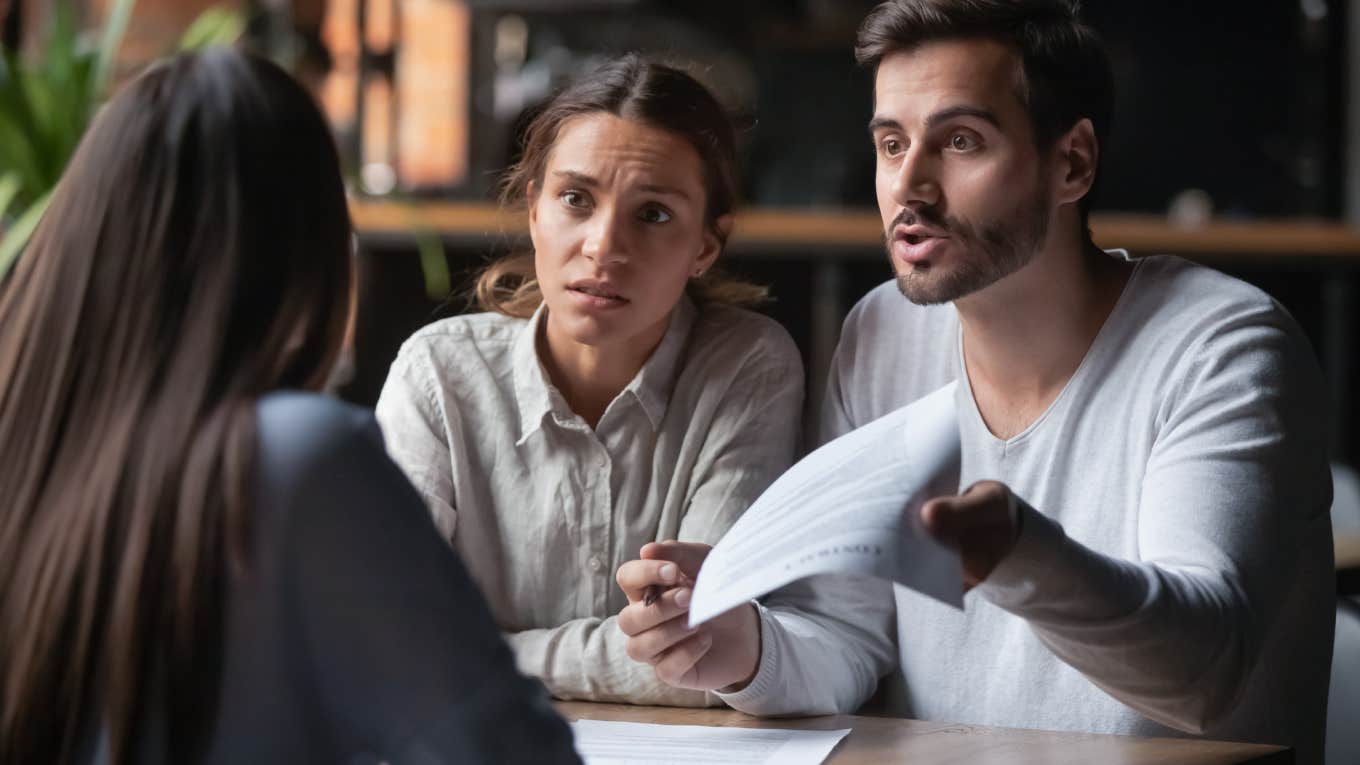 Former Property Manager Shares Hack To Negotiate Rent Price If It's Being Raised angry couple holding papers while talking to manager
