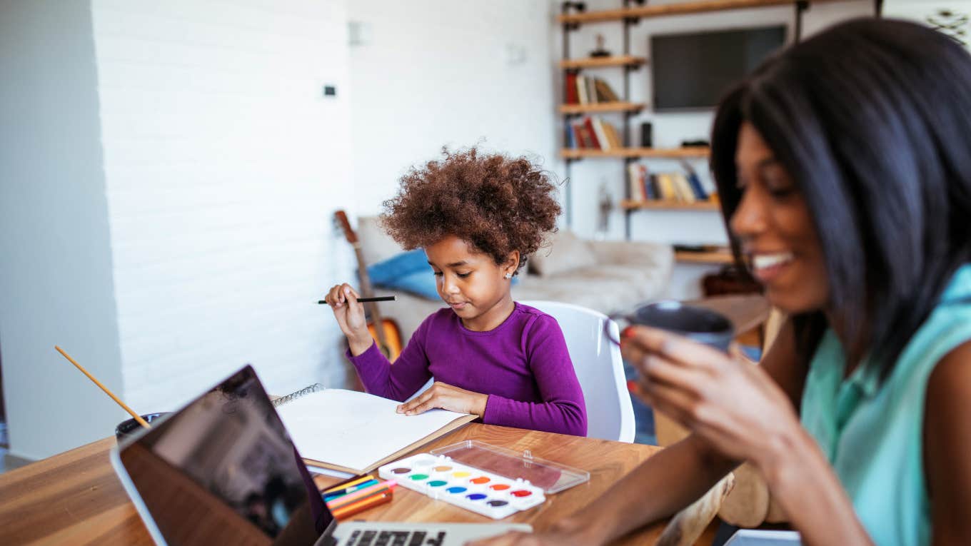 Mom Has To Neglect Her Kid To Do Her New Work-From-Home Job mom working on computer with daughter sitting next to her painting