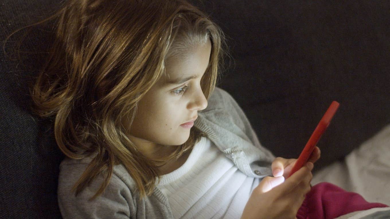 Best Way For Parents To Manage Kids' Social Media, According To A Parenting Coach kid on cellphone