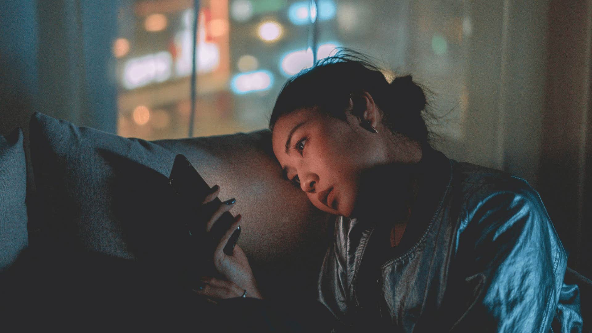 forlorn sad woman looking at phone