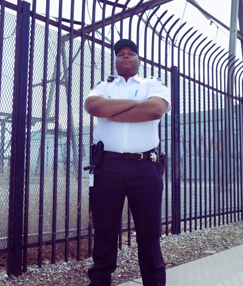 prison guard standing with arms crossed