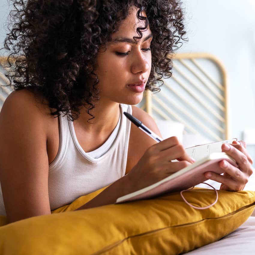 Woman writes in journal about uncontrollable grumpiness