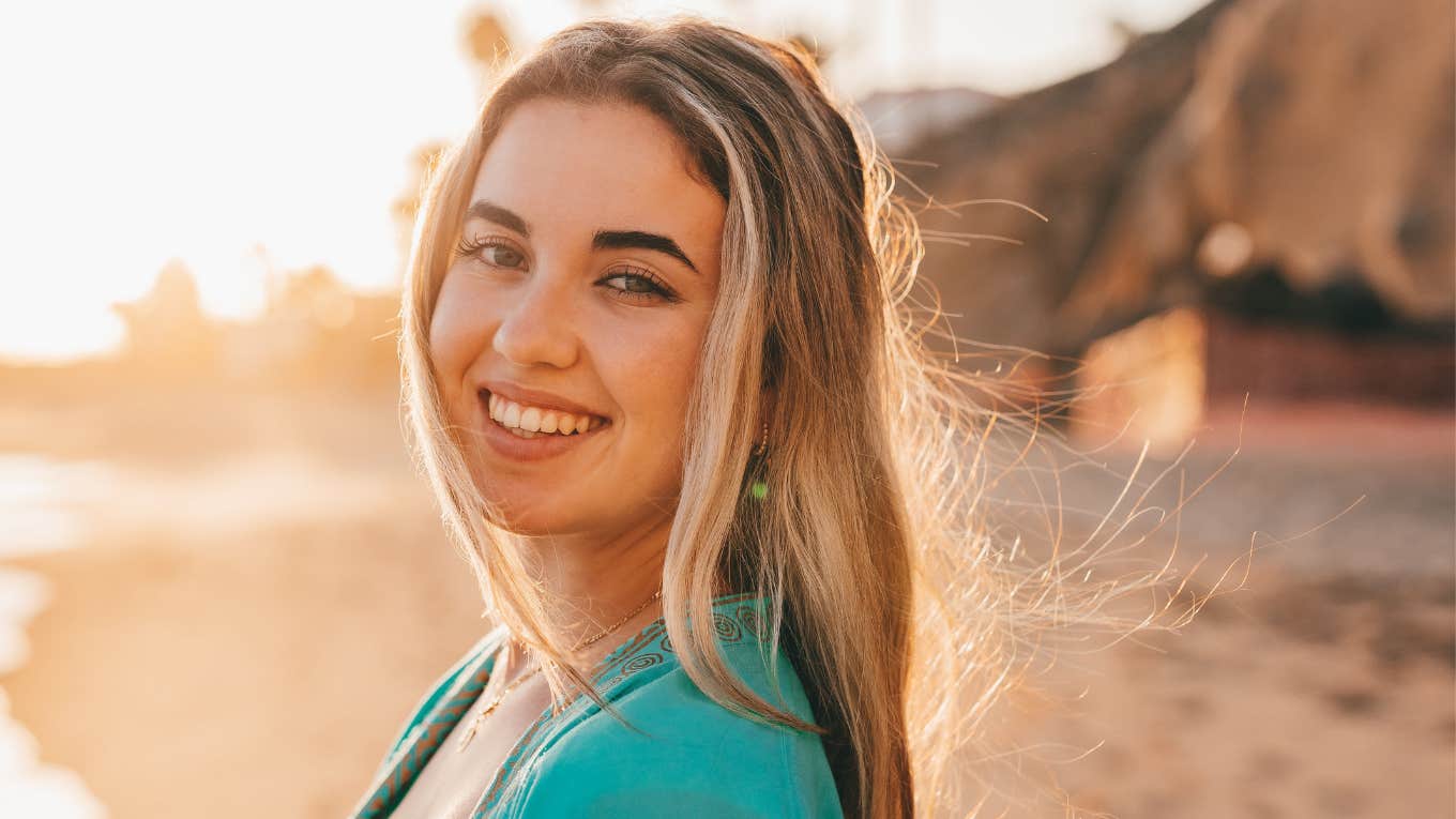 Signs The Universe Sends When Hard Times Are Coming To An End smiling woman feeling free