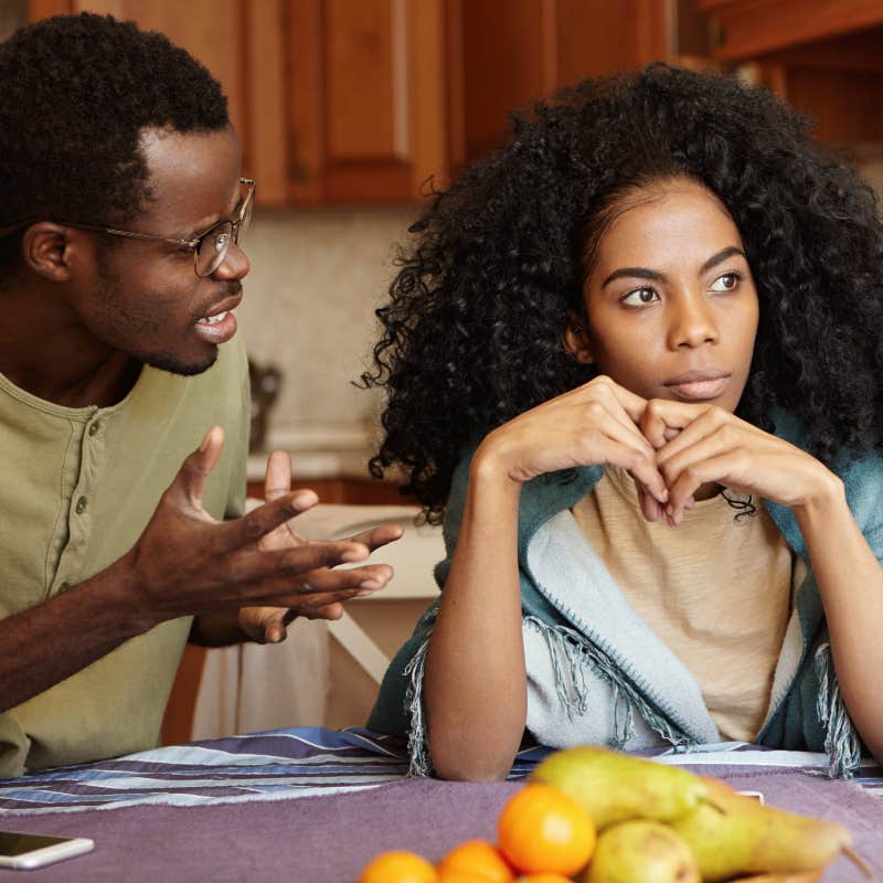 couple arguing at dining table in kitchen