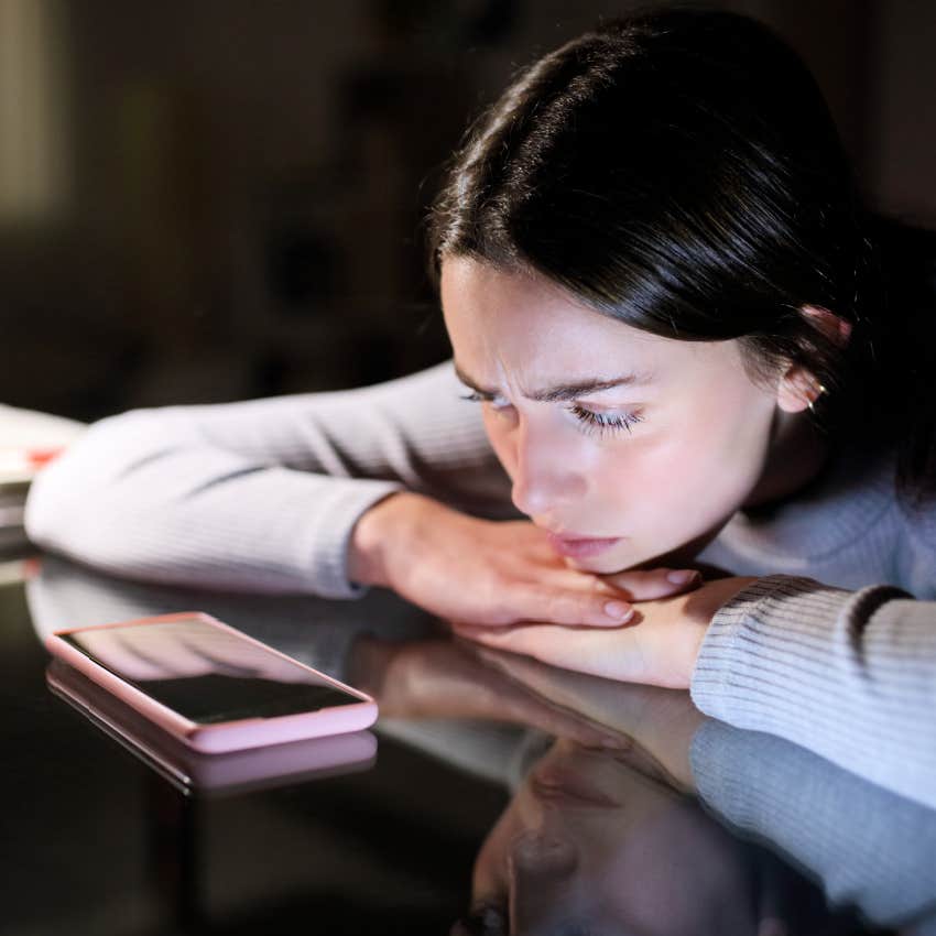 woman looking at her phone waiting for a text or call