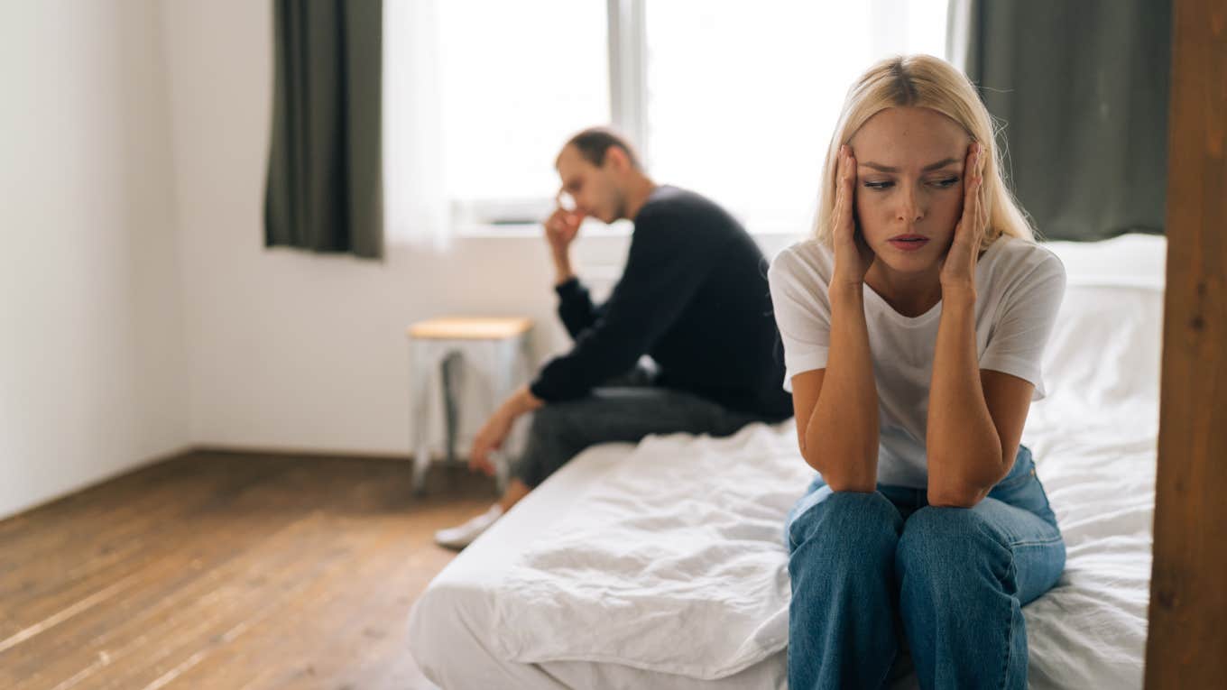 Woman Feels Resentful After Her Boyfriend Of 5 Years Refuses To Marry Her couple sitting separate on bed with backs turned ignoring each other after fight