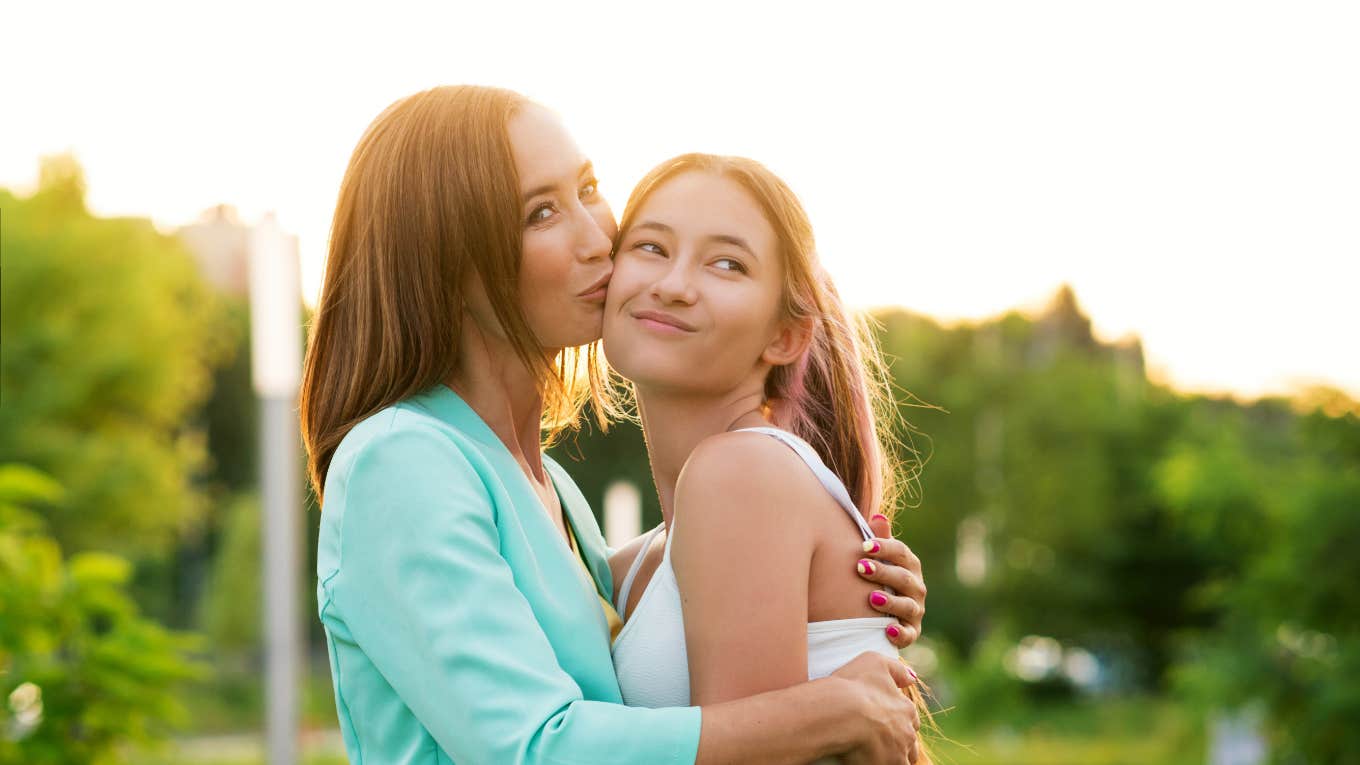 Stepdad Urges His Wife To ‘Enforce’ Better Eating Habits In Her ‘Active’ Daughter mom embracing and kissing her teen daughter's cheek outside