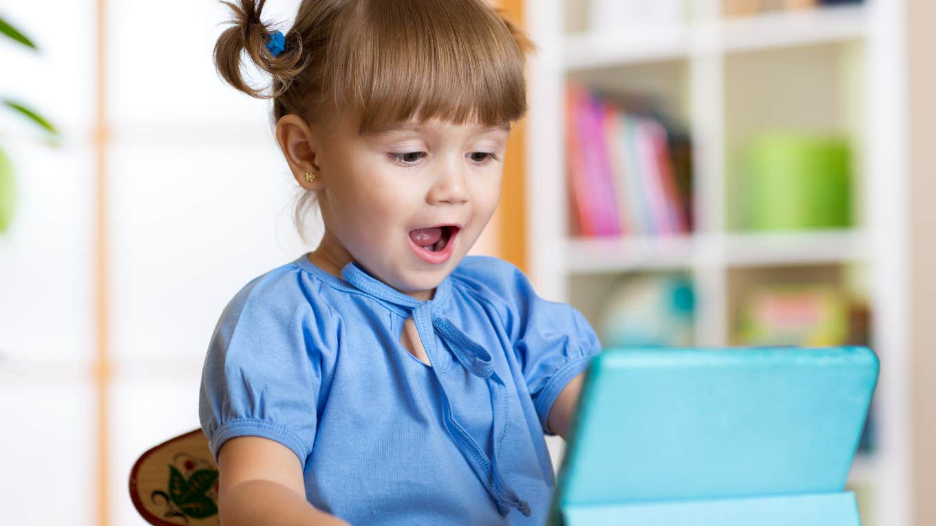 Dad Shares Positive Ways His Kid Uses Screen Time little girl looking happy using a tablet