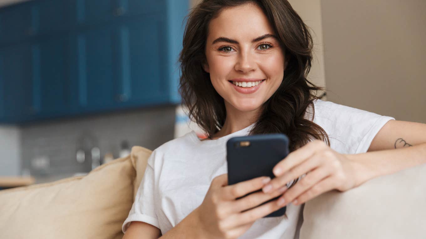 Gen Zer Says 'It's Time To Get Off That Phone' young woman smiling at camera holding her phone