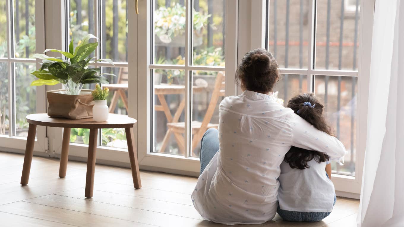 6 Life Skills People Raised By Single Moms Learn That Others Don't mother and daughter hugging while looking out a window