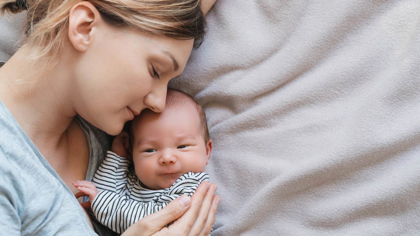 Mom 'Struggling With Name Regret' For Her Month-Old Son mom laying down on blanket holding baby boy