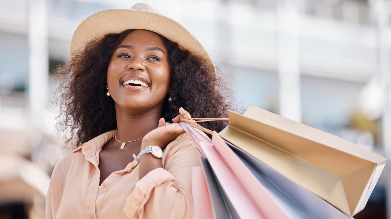 People Convinced In-Person Shopping Will Soon Be Obsolete Smiling woman wearing hat and carrying shopping bags