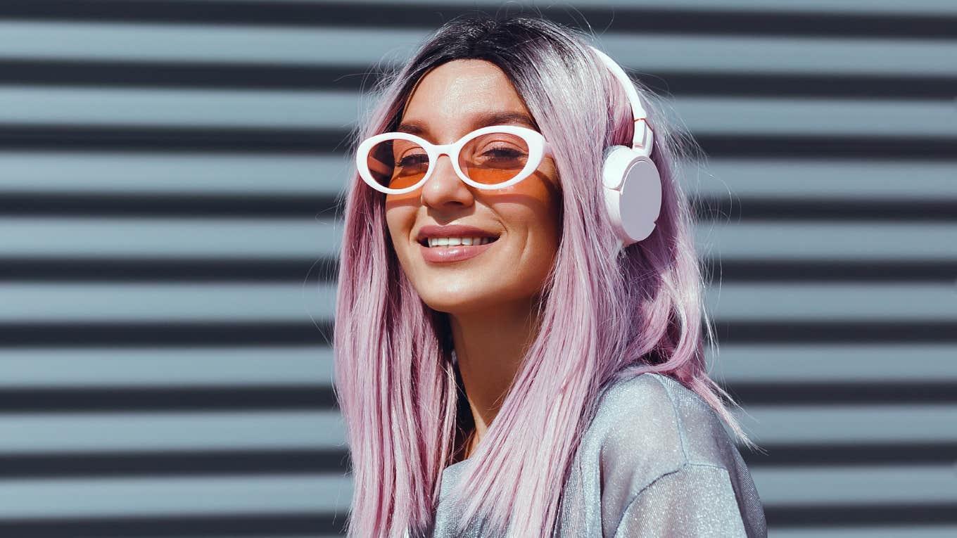 Rare Traits People Who Never Fit In Growing Up Develop Later In Life woman with purple hair smiling bright
