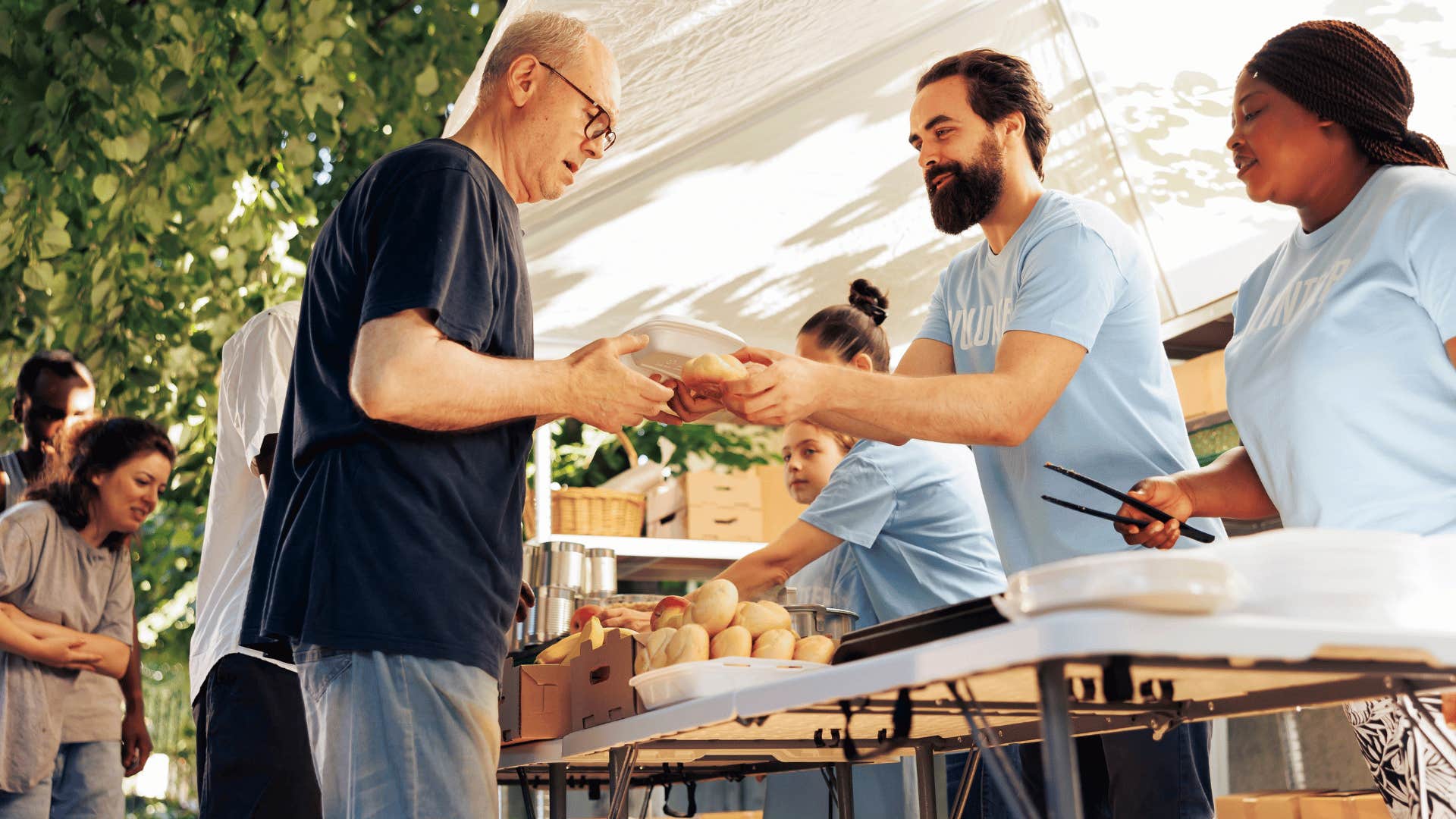 man passing out food to other man 