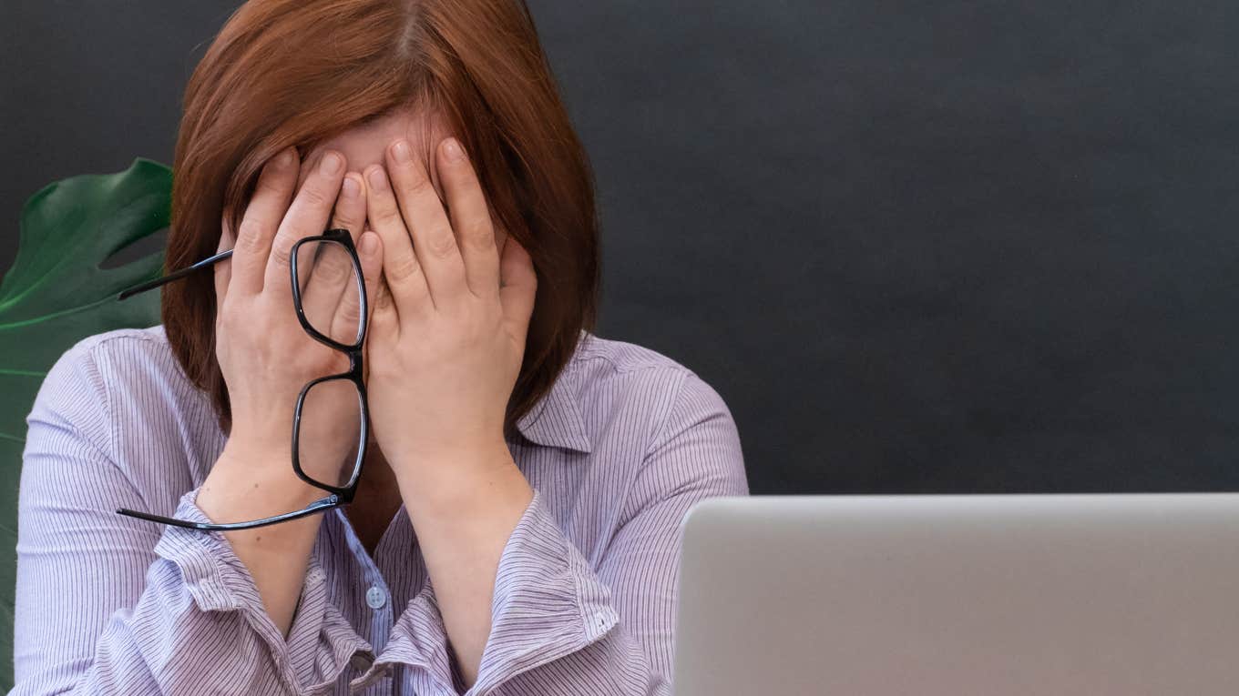 Student's Parents Show Up Unannounced At Teacher's Home frustrated teacher with head in hands in front of black board