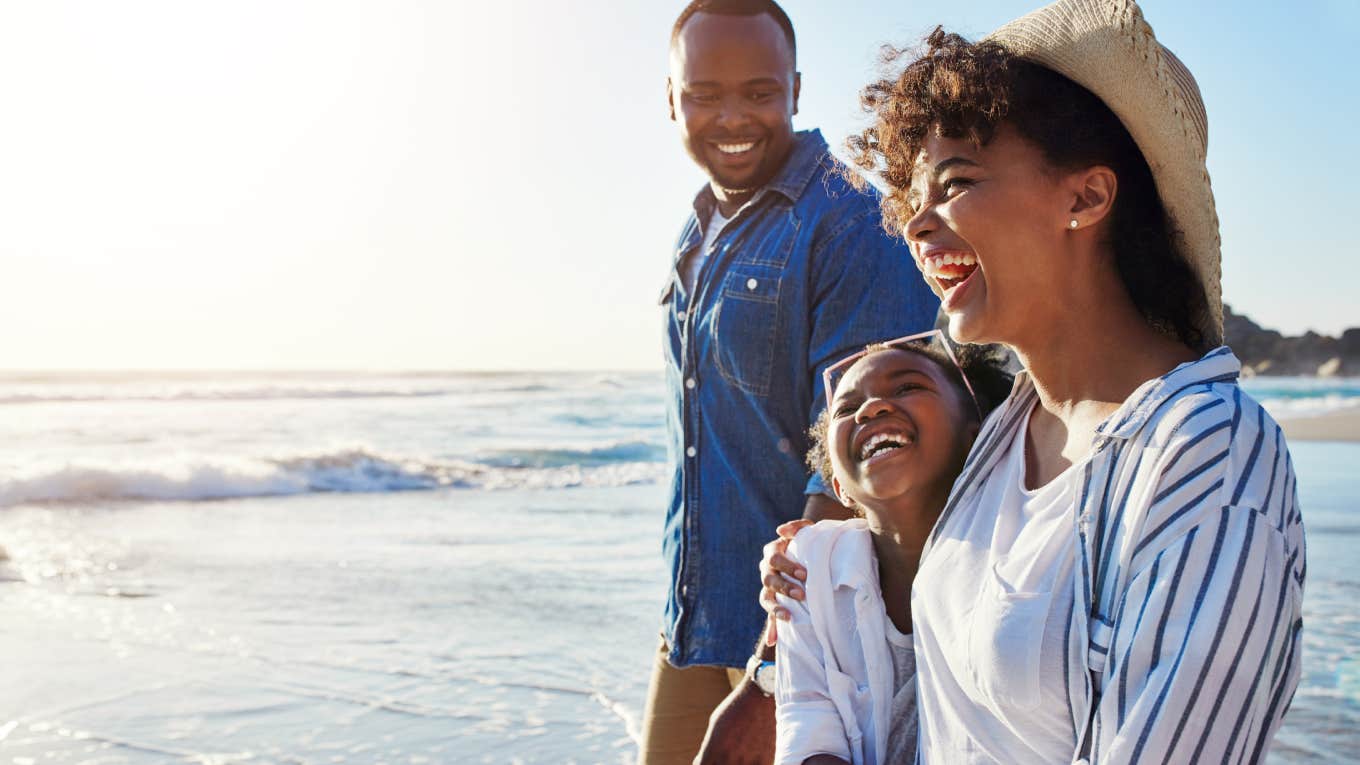 Study Finds Americans Are Still Going On Vacation Even Though Most Can't Afford It family walking together on vacation by the beach