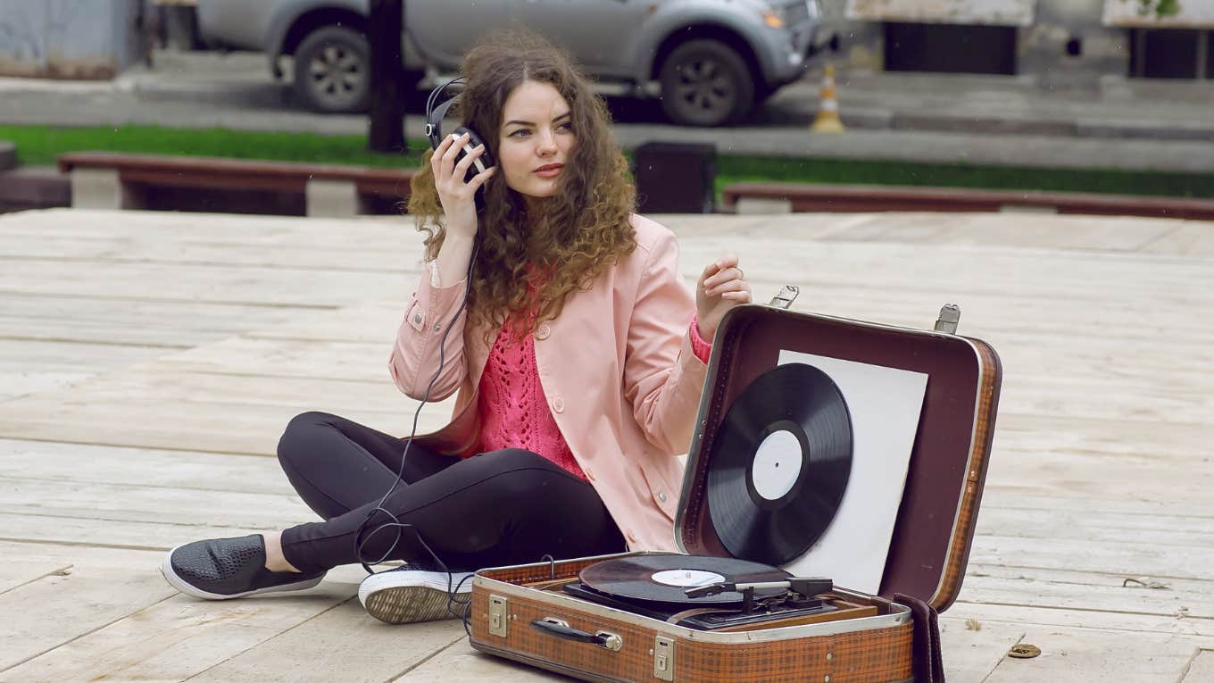 Teen's Christian Mom Destroys Her Olivia Rodrigo Records teenager sitting next to a record player listening to music