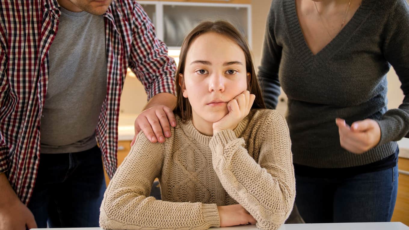 Types Of Toxic Families And How Each One Impacts Their Kids upset teen with parents fighting behind her