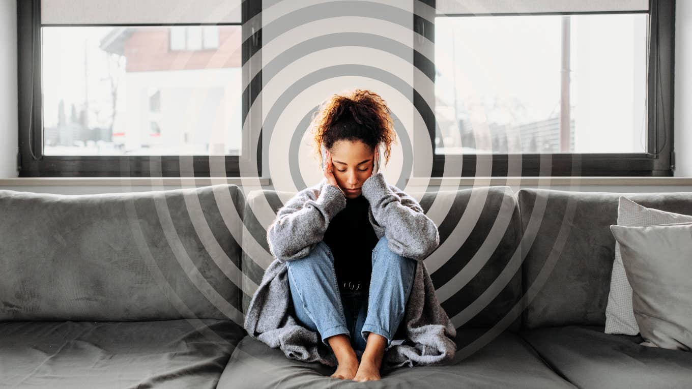 Ways Your Body Warns You When You're Stuck In A Low Vibration Pattern Woman fatigued with a headache, stuck in low vibrational pattern