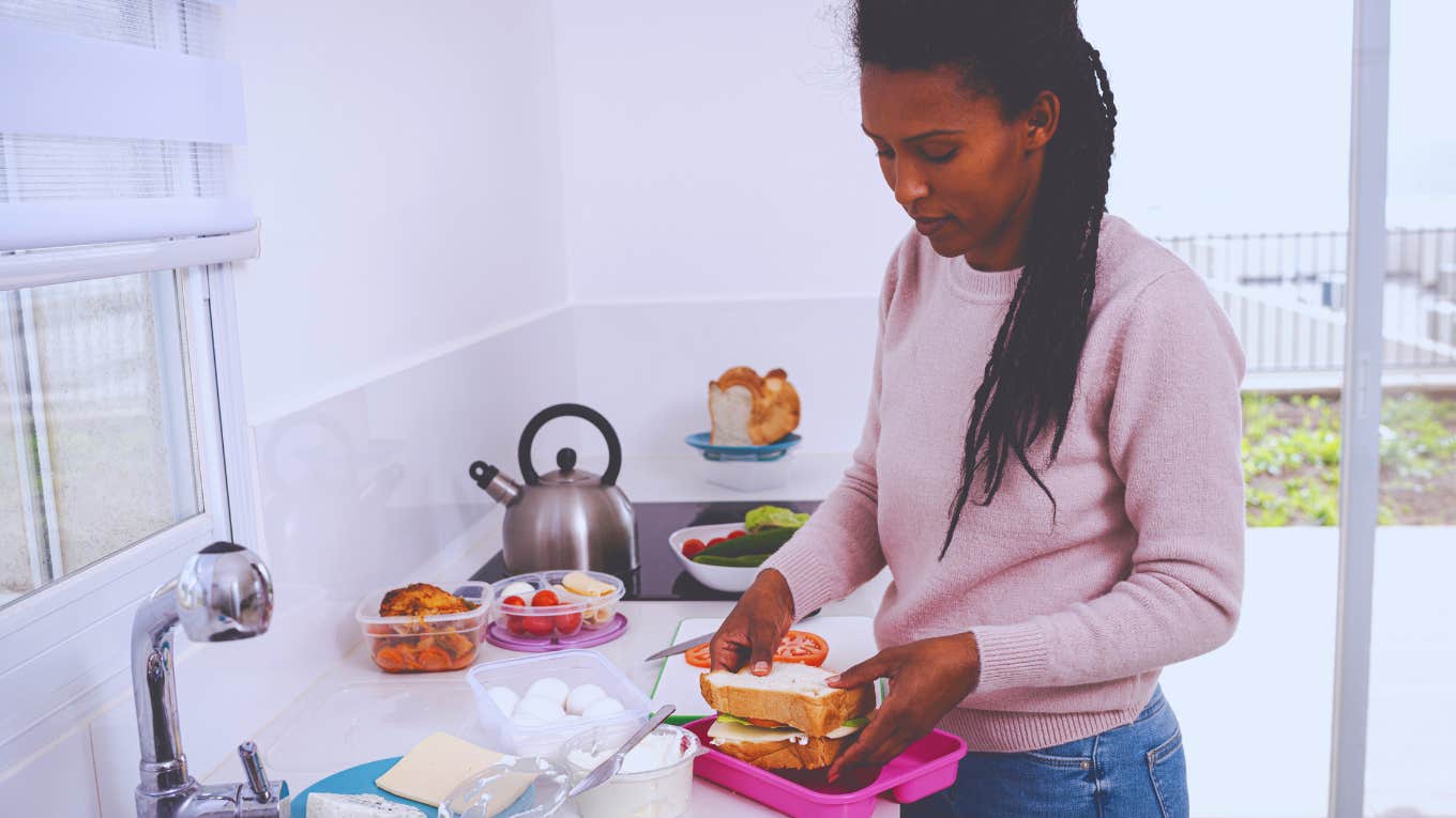 Wife Of Embarrasses Husband By Bringing His Favorite Lunch To Work woman packing a lunch in her kitchen