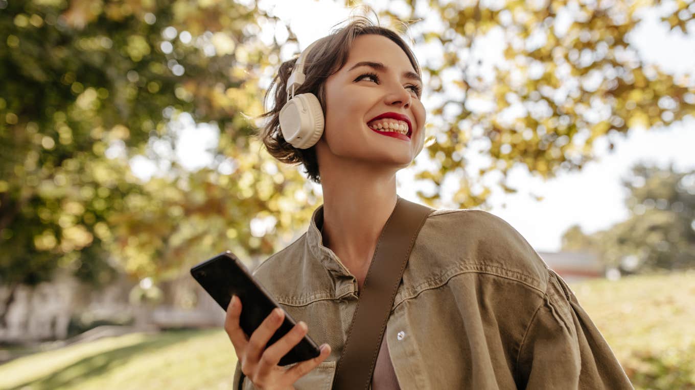 Worker Quit Her Job With Only $500 In The Bank But Says Walking Everyday Made Her Financially Free smiling woman wearing headphones walking outside