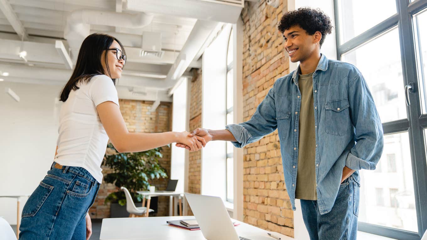 Career Coach Says One Question Can Determine Your Success two co-workers shaking hands across a desk