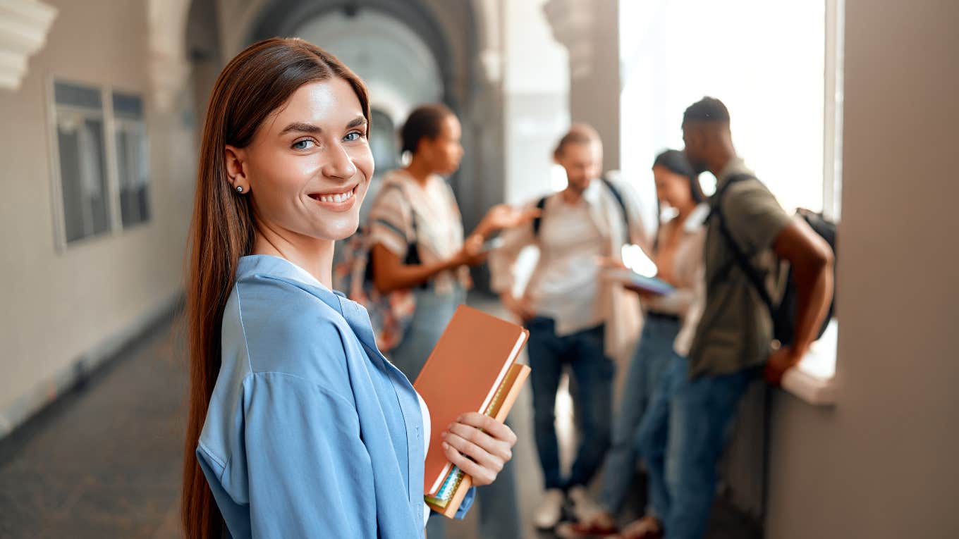 College Moms Try To Set Up Playdates For Their Children college student standing by herself near a group of students
