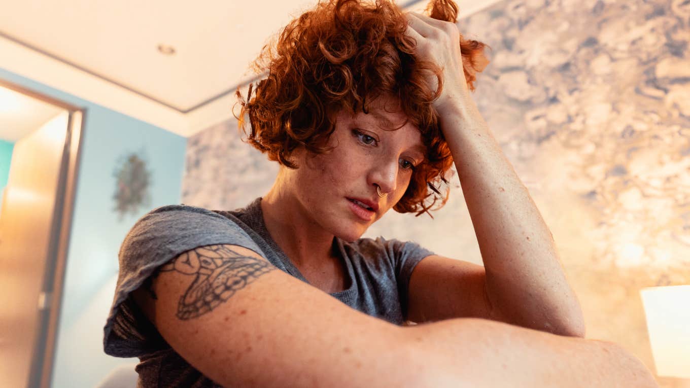 4 Clear Signs Someone Is Extremely Envious Of You, According To The Laws Of Human Nature Woman looking envious sitting in her home.