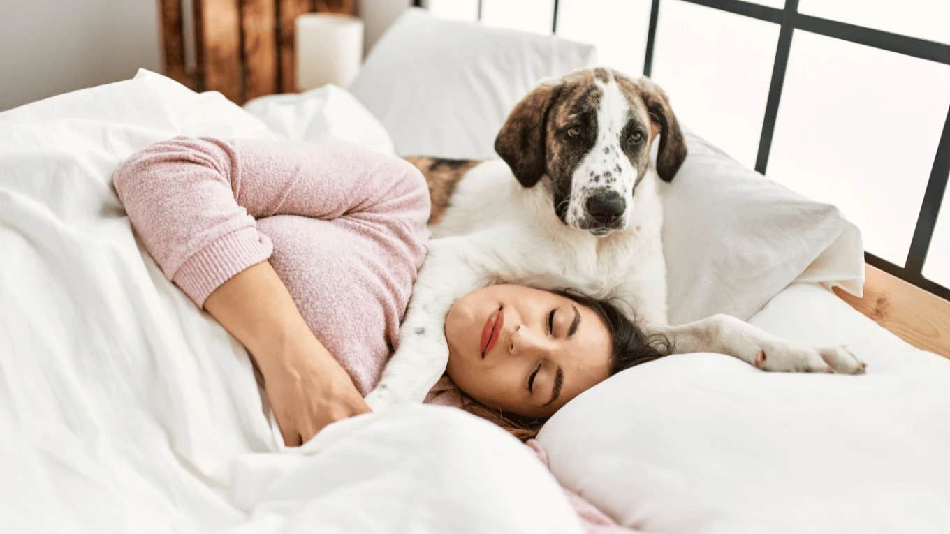 How To Tell If Your Dog Is Happy Based On Their Sleeping Position Woman sleeping with happy dog