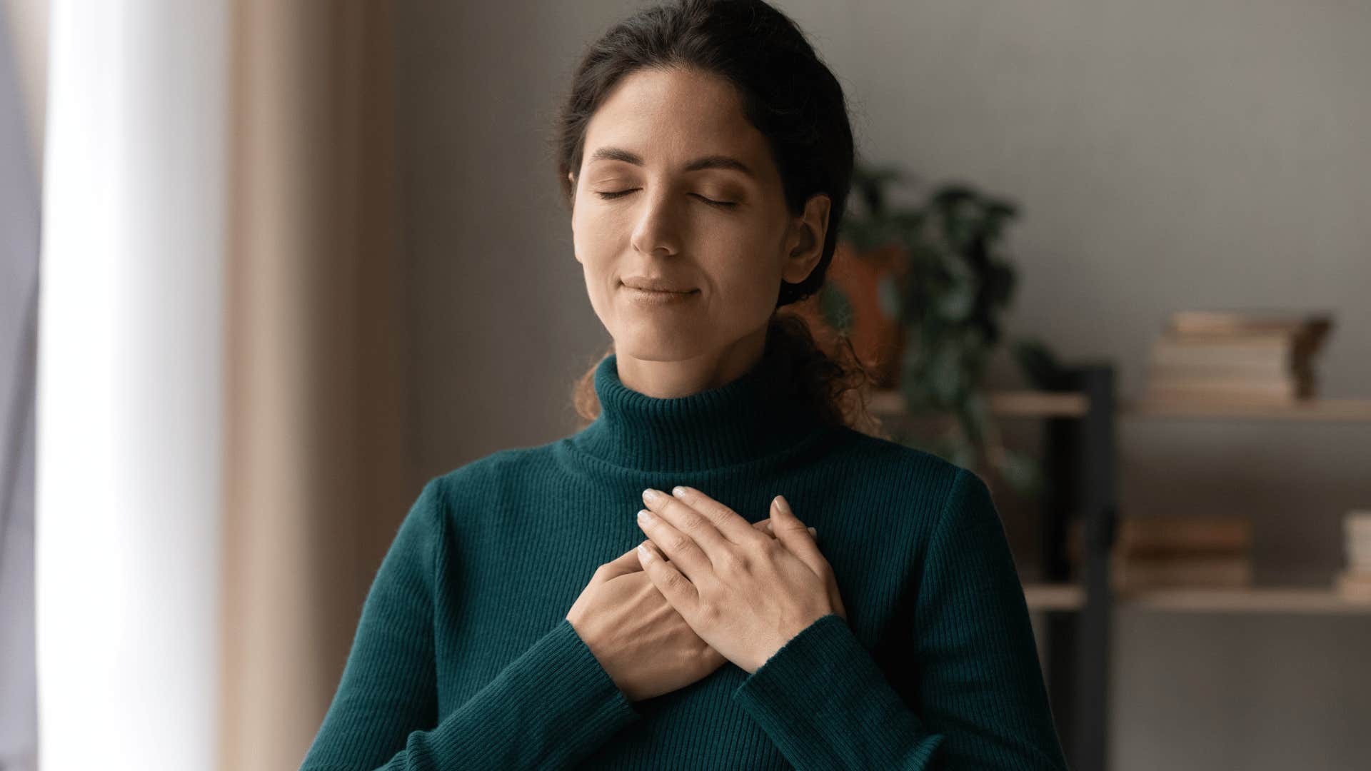woman putting hand over heart and breathing calmly 
