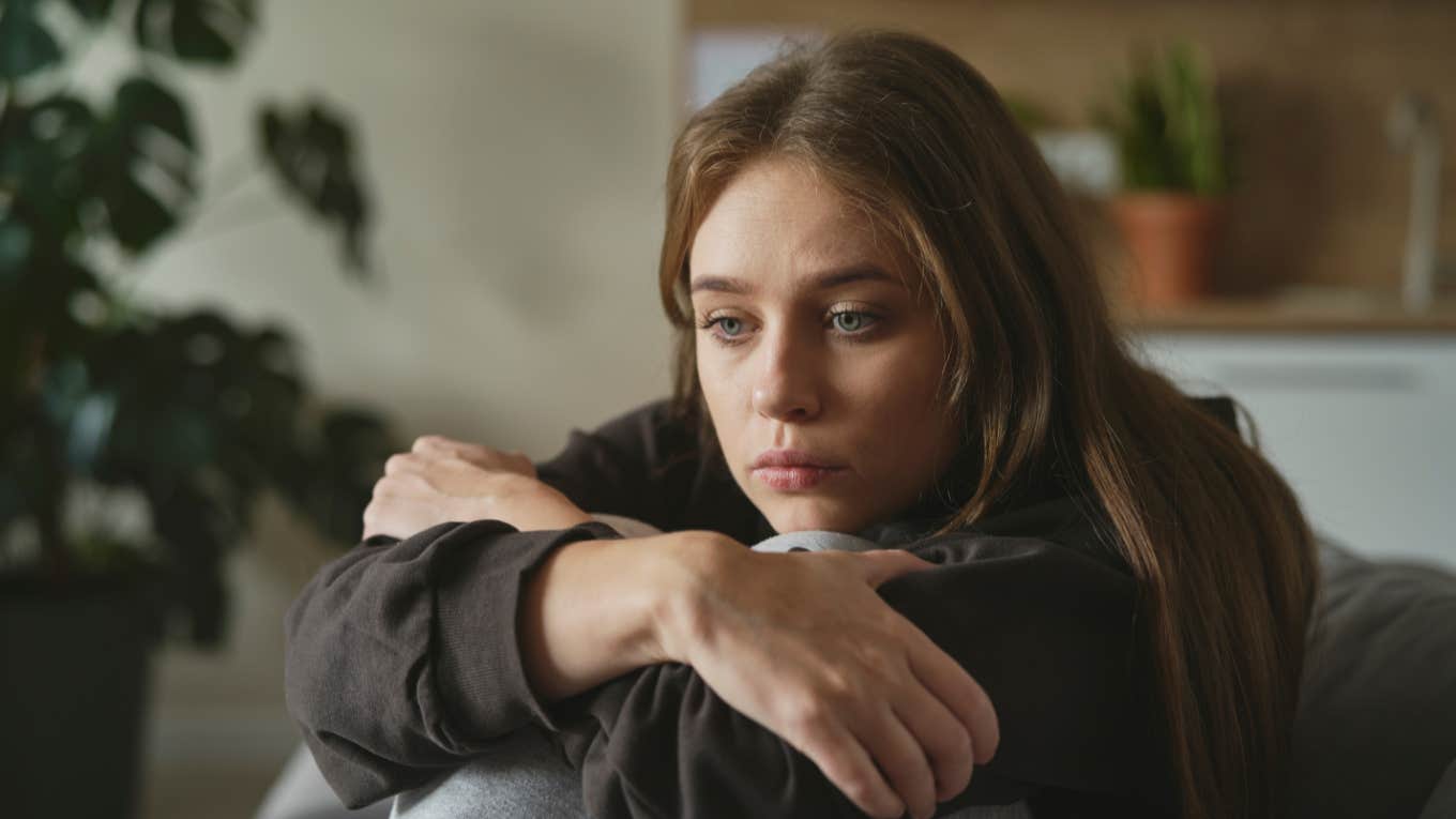 Wife Has No Money Because Of Prenup And Isn't Allowed To Work Sad wife sitting with her arms wrapped around her knees