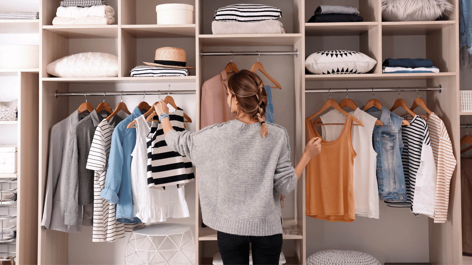 young woman choosing an outfit from a wardrobe