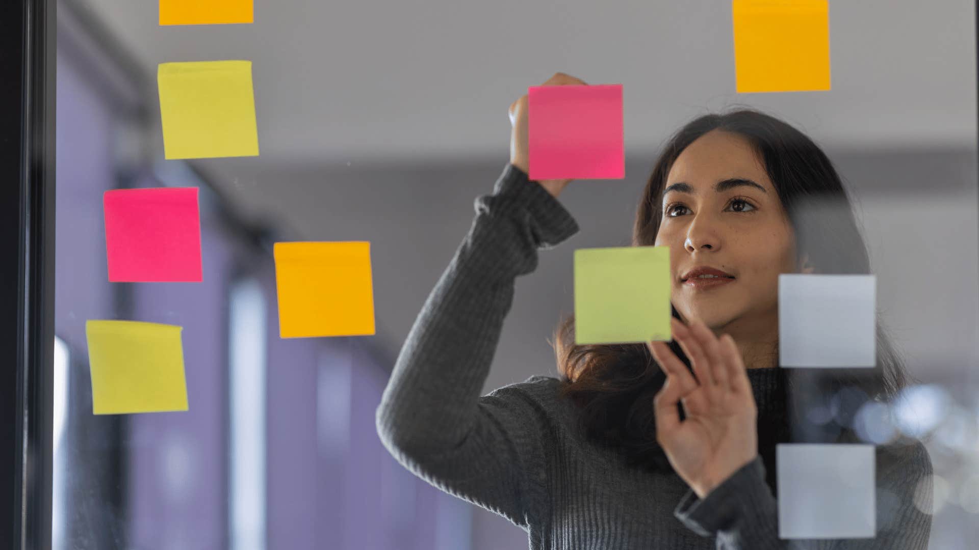young woman writing and arranging sticky notes
