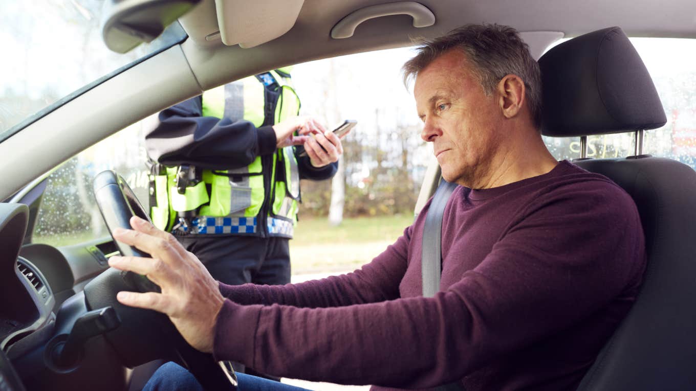 Lawsuit Alleges Tennessee Troopers Arrested Sober Driver For DUI Because He Knew His Brother cop pulling over frustrated driver sitting in car with hands on wheel