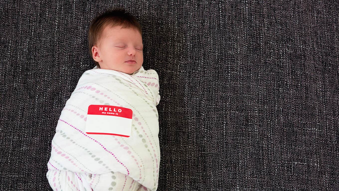 Mom Has Startling Realization About Millennial Names After Talking To Daughters Swaddled infant wearing name sticker