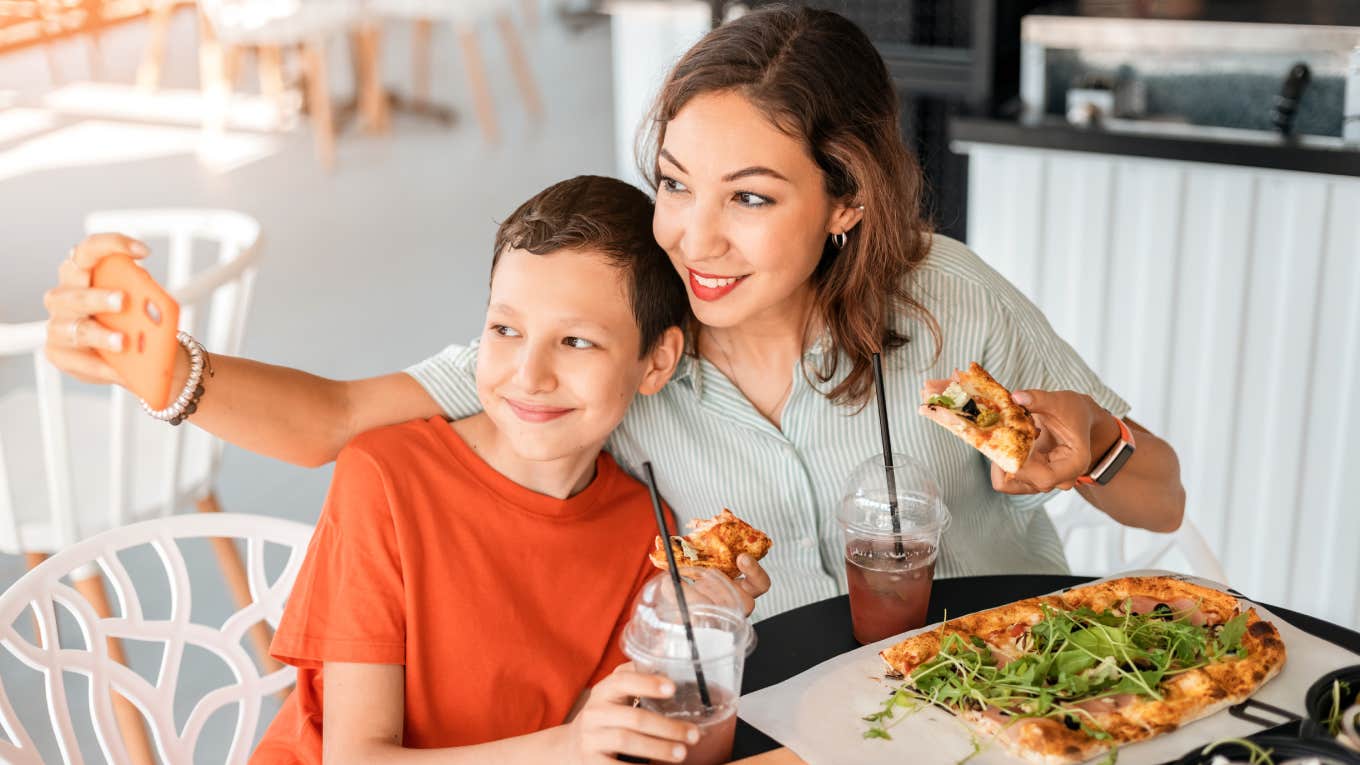 Mom Faces Accusations After Admitting That She Makes Her Son Take Her On Dates To Teach Him To Be A Good Partner mom and son taking picture together eating at restaurant