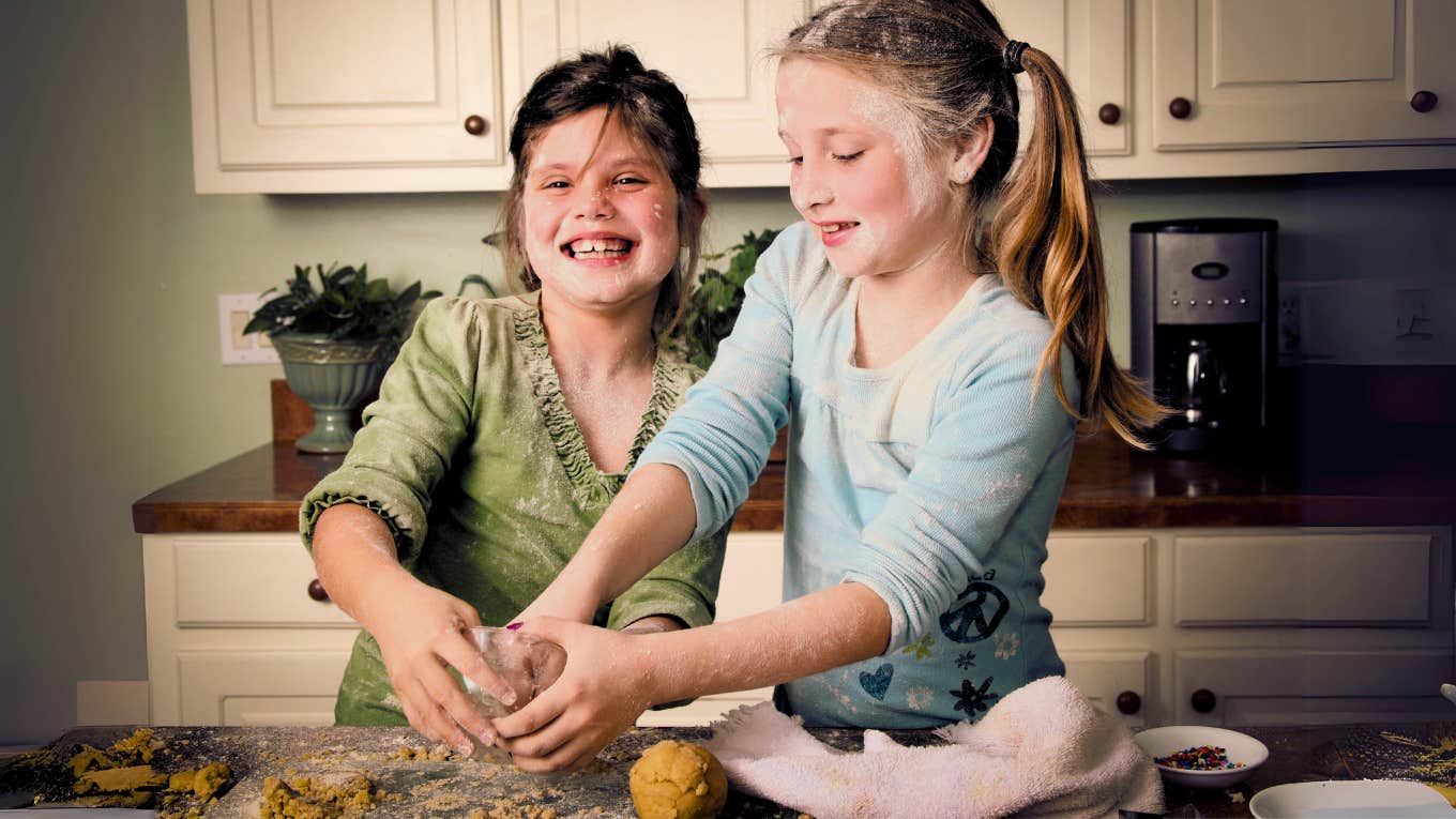 My 1980s Parenting Attempt Was A Total Disaster Mother taking hands off 1980's parenting approach while children bake in kitchen making a mess.