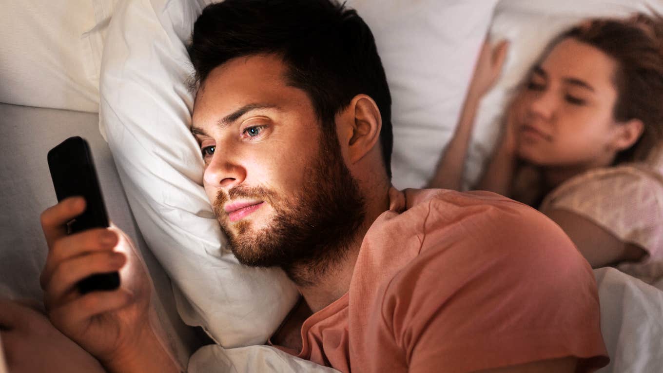 The Primary Reason People Cheat, Hands Down Man emotionally cheating late at night on phone, while wife is in bed next to him.