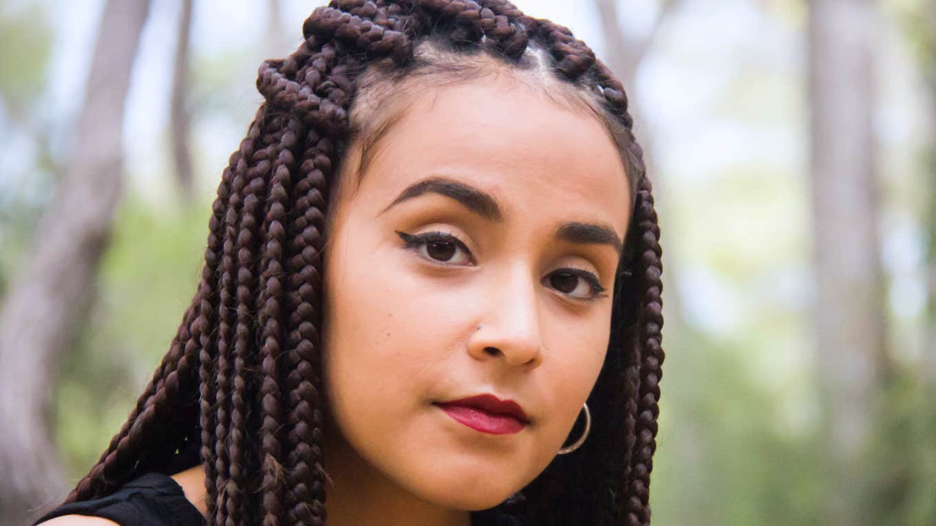 Quiet Ways People Get Revenge Without Getting Caught woman with braids thinking