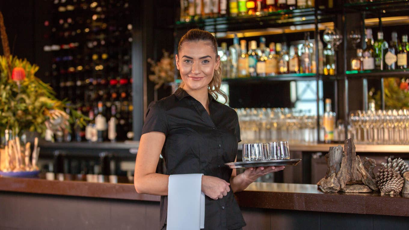 Server Shares 6 Things She Does To Show Her Tables Who's Boss Server smiling while holding water glasses