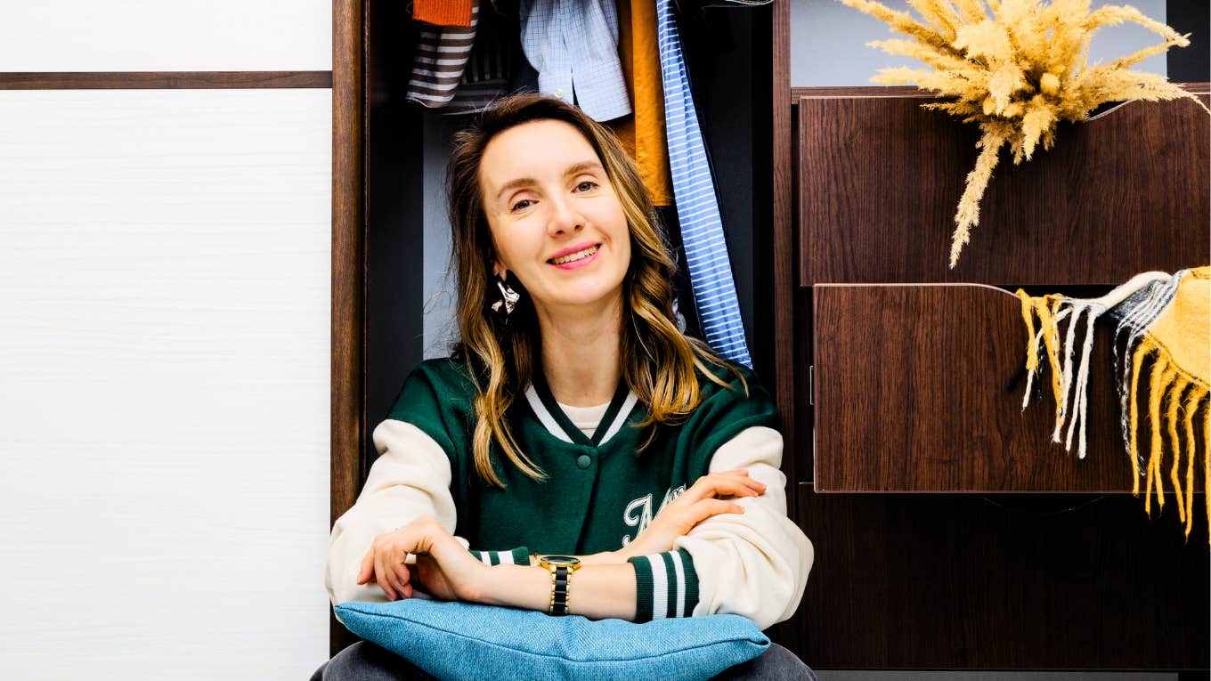 Stop Buying These Things To Retire Ten Years Early Woman sitting in closet not shopping to retire ten years early.