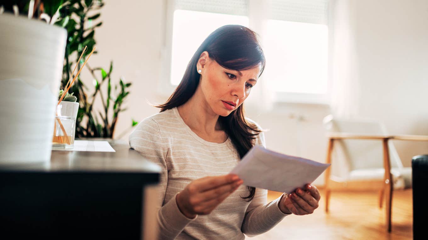 Subtle Signs A Man Is Financially Cheating On You Woman opening bill, finding out that man is financially cheating on you.