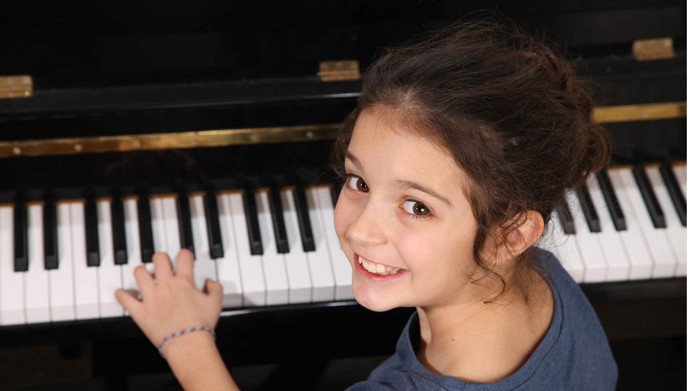 Single Dad Kicks Parents Out After They Mocked His Daughter’s Piano Performance Little girl smiling while playing piano