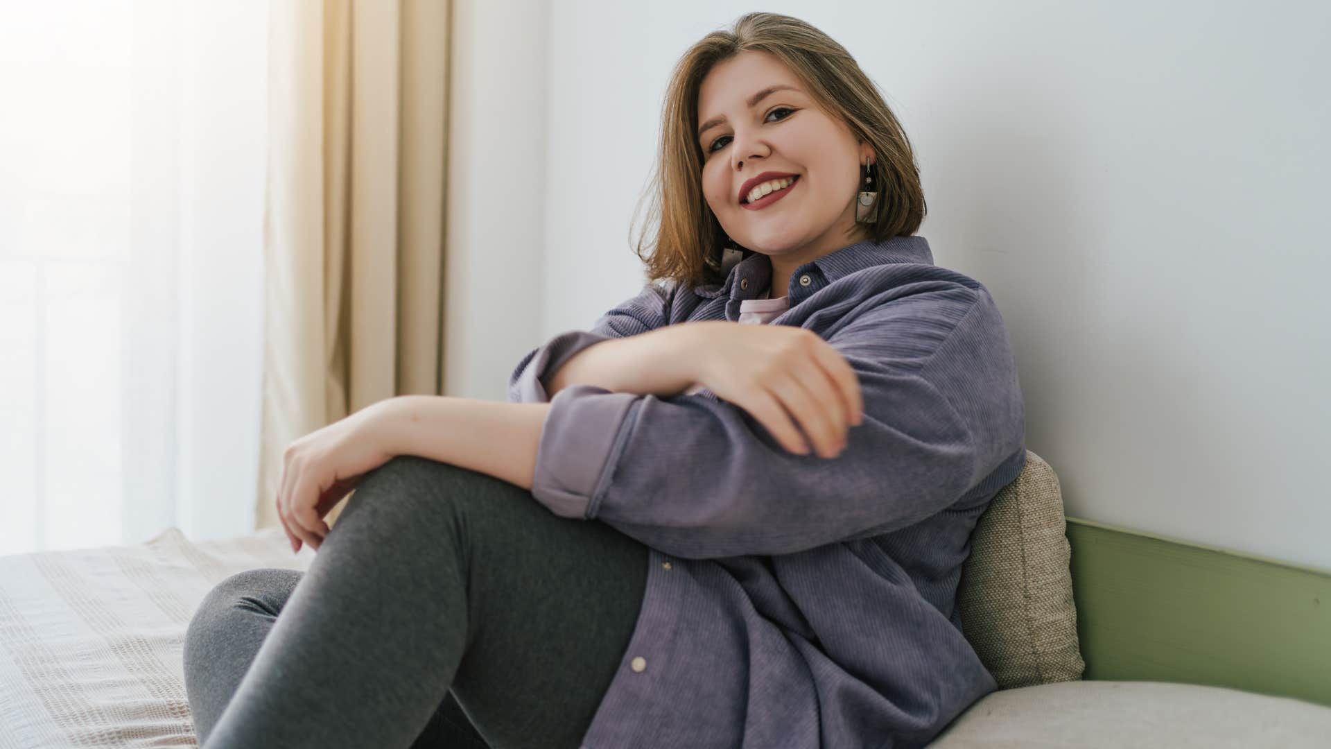 Young woman sitting alone on her couch.