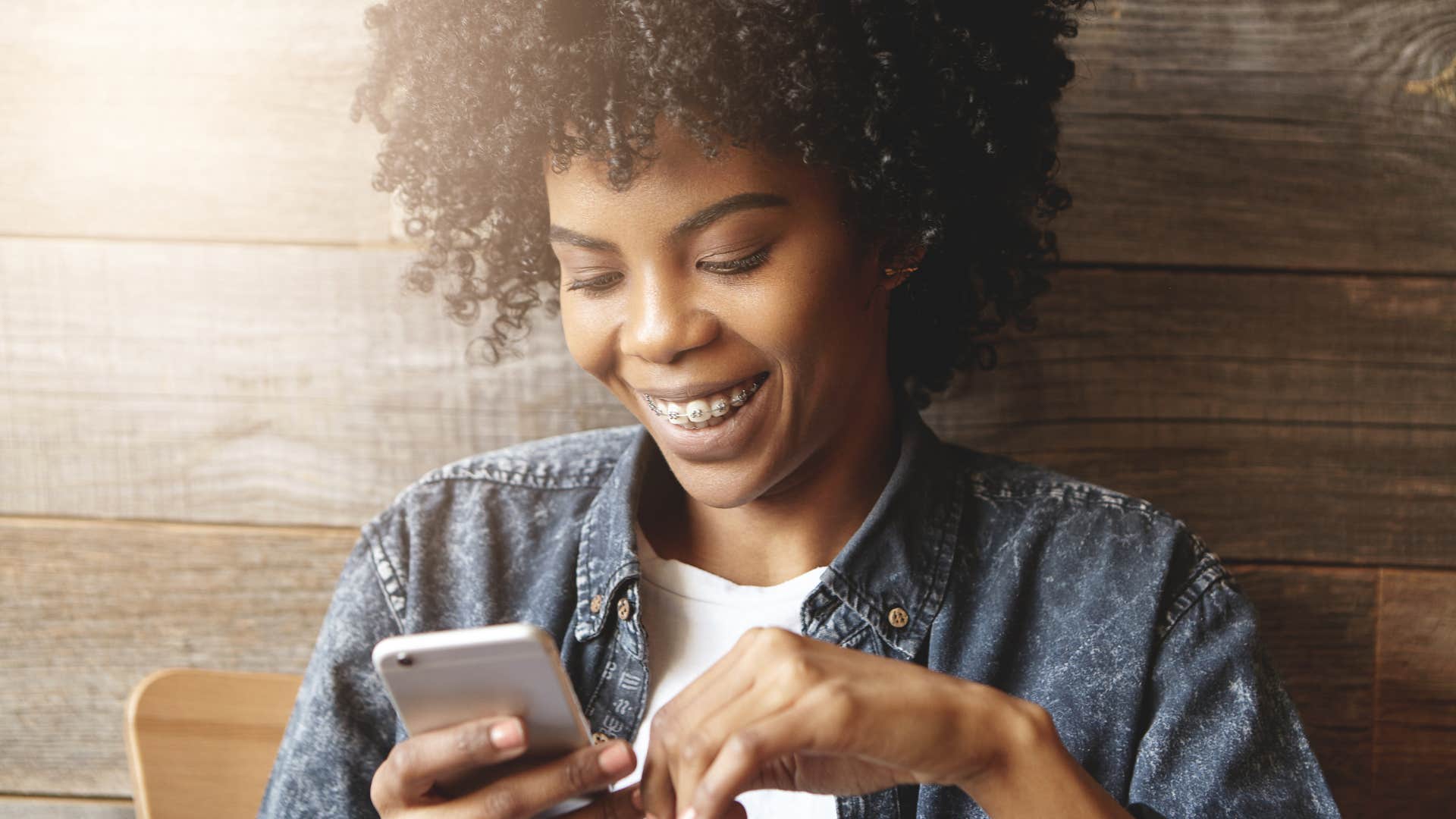 Young woman smiling at her phone.