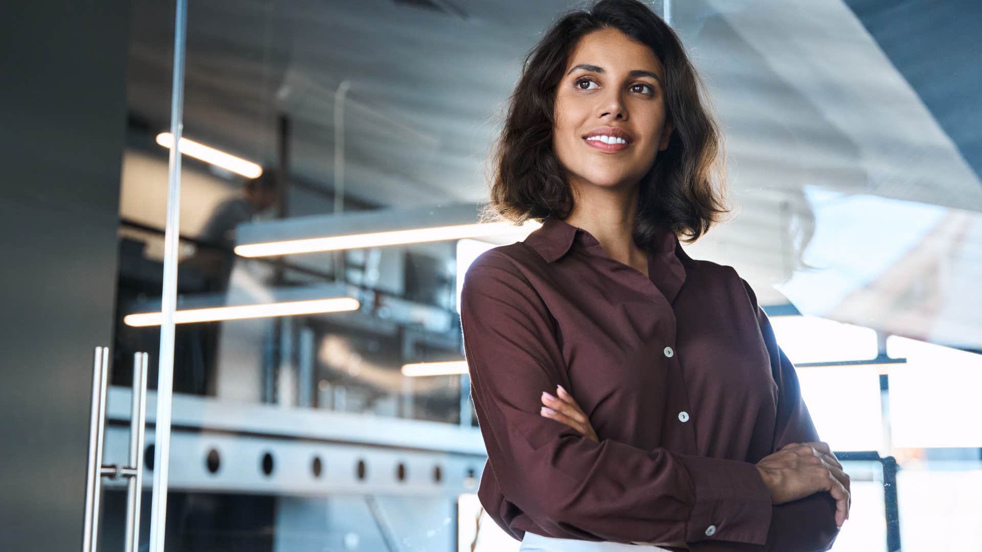 Young professional woman crossing her arms and smiling.