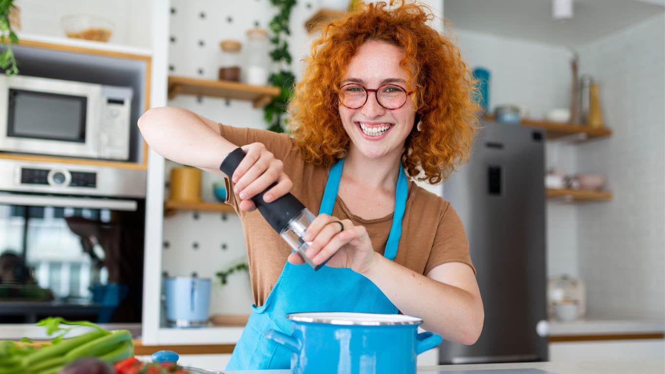 Mother-In-Law Claims Daughter-In-Law Is Forcing An Alternative Lifestyle By Cooking Vegan Thanksgiving Woman smiling while cooking vegan Thanksgiving meal
